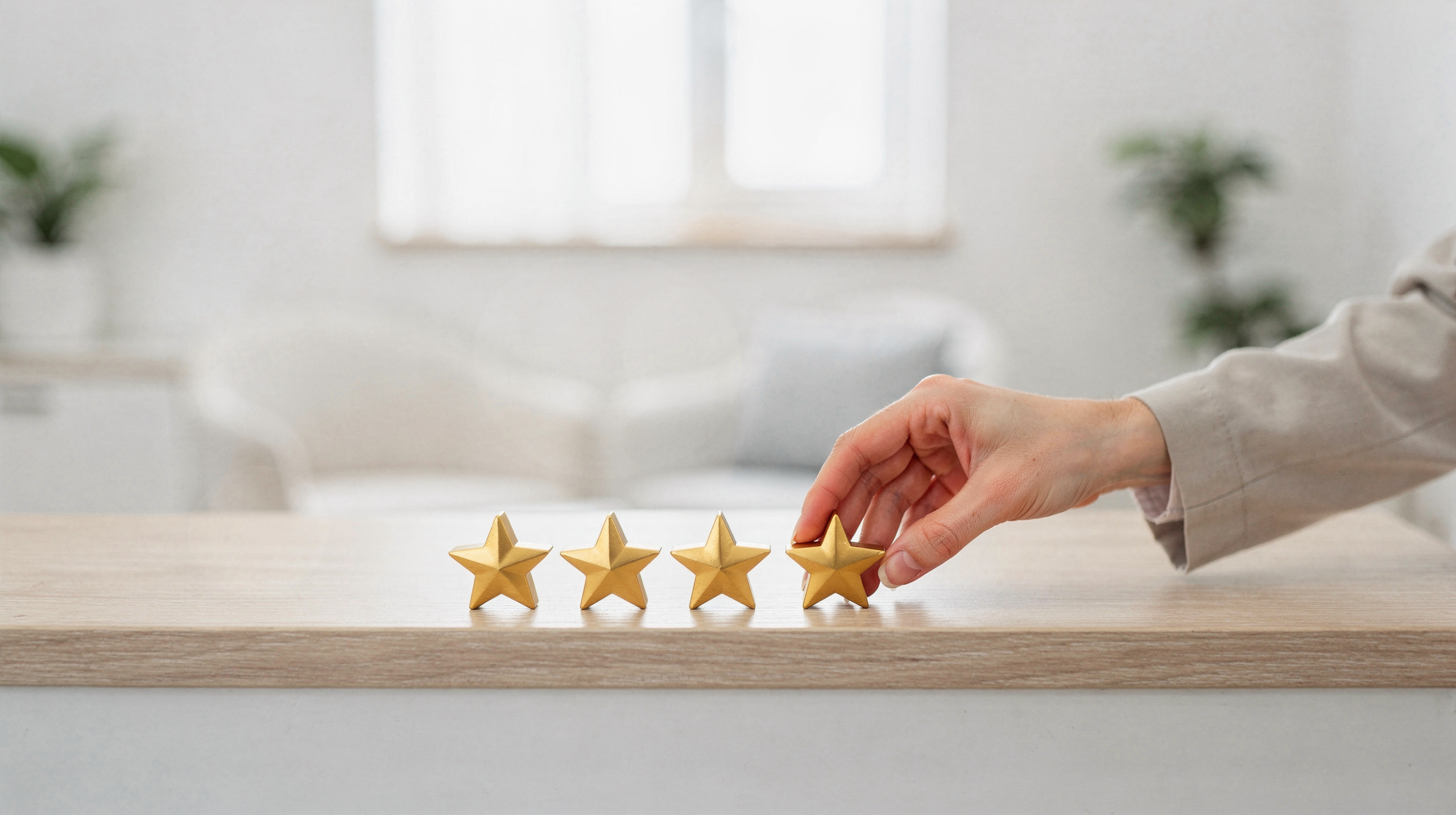 Hand placing a fifth gold star on a wooden table in a modern clinical waiting room